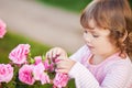 Adorable little girl smelling garden roses. Royalty Free Stock Photo