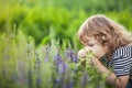 Adorable toddler girl smelling purple flowers. Royalty Free Stock Photo