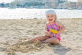 Adorable toddler girl smiling and playing on white sand beach seaside Royalty Free Stock Photo