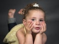 Two year old girl lying chin on hands