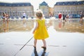 Toddler girl having fun famous outdoor water fountain Miroir d`eau in Bordeaux Royalty Free Stock Photo