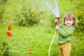 Adorable toddler little helper watering the garden and having fun