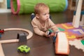 Adorable toddler playing with car toy lying on floor at kindergarten Royalty Free Stock Photo