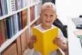 Adorable toddler reading book standing at classroom Royalty Free Stock Photo