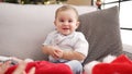 Adorable toddler smiling confident sitting on sofa by christmas tree at home Royalty Free Stock Photo