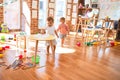 Adorable toddlers, girl drawing using pencil around lots of toys at kindergarten