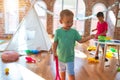 Adorable toddlers playing around lots of toys at kindergarten