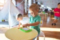 Adorable toddlers playing around lots of toys at kindergarten