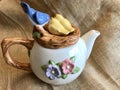 Adorable Whimsical Blue Bird and Chicks Floral Teapot on Burlap background