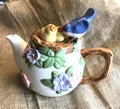 Adorable Whimsical Blue Bird and Chicks Floral Teapot on Burlap background