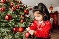 Christmas portrait of adorable 3 year old asian toddler girl wearing red Santa dress and hat Royalty Free Stock Photo