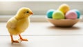 Easter chick standing on table with blurred colorful eggs in background cute spring holiday symbol for festive design Royalty Free Stock Photo