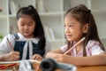 An adorable young Asian elementary school girl is focusing on studying in the classroom Royalty Free Stock Photo