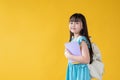 An adorable young Asian girl with books in her hand and a backpack. kids, elementary school student Royalty Free Stock Photo