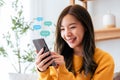Adorable young Asian woman using mobile smartphone Royalty Free Stock Photo