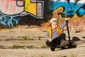 Adorable young boy sitting with his scooter Royalty Free Stock Photo