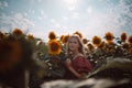 Adorable young caucasian girl model posing in a sunflower field in the sun light. Blooming sunflowers. Beauty sunset Royalty Free Stock Photo