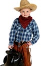 Adorable young cowboy hands on hip holding saddle