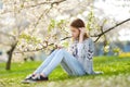 Adorable young girl in blooming cherry tree garden on beautiful spring day. Cute child picking fresh cherry tree flowers at spring Royalty Free Stock Photo