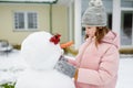 Adorable young girl building a snowman in the backyard. Cute child playing in a snow Royalty Free Stock Photo