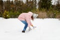 Adorable young girl building a snowman in the backyard. Cute child playing in a snow Royalty Free Stock Photo