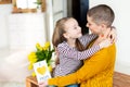 Adorable young girl giving her mom, young cancer patient, homemade I LOVE MOM greeting card. Happy Mother`s Day or Birthday.