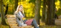 Adorable young girl having fun on beautiful autumn day. Happy teenager portrait in autumn park Royalty Free Stock Photo