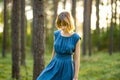 Adorable young girl having fun in a forest. Happy teenager portrait in summer park. Teen wearing blue dress Royalty Free Stock Photo