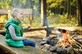 Adorable young girl roasting marshmallows on stick at bonfire. Child having fun at camp fire. Camping with children in fall forest Royalty Free Stock Photo