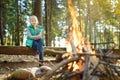 Adorable young girl roasting marshmallows on stick at bonfire. Child having fun at camp fire. Camping with children in fall forest Royalty Free Stock Photo