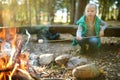 Adorable young girl roasting marshmallows on stick at bonfire. Child having fun at camp fire. Camping with children in fall forest Royalty Free Stock Photo