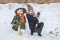 Adorable young girl is taking pictures of selfie with a snowman in beautiful winter park. Winter activities for children. Closeup