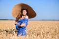 Young girl in a wide-brimmed hat in a wheat field Royalty Free Stock Photo