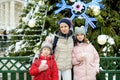 Adorable young girls and their mom having wonderful time on traditional Christmas market