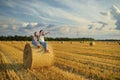 Adorable young sisters having fun in a wheat field on a summer day. Children playing at hay bale field during harvest time. Kids Royalty Free Stock Photo