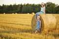 Adorable young sisters having fun in a wheat field on a summer day. Children playing at hay bale field during harvest time. Kids Royalty Free Stock Photo