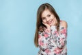 Adorable young smiling girl with attitude. Cheeky child waist up portrait on pastel coloured blue background. Royalty Free Stock Photo