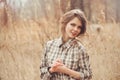 Adorable young woman in plaid shirt on cozy country walk on field