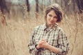 Adorable young woman in plaid shirt on cozy country walk on field