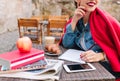 Adorable young woman is waiting for the inspiration to draw a picture. Charming girl makes notes in a notebook during Royalty Free Stock Photo