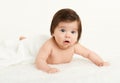 Adorably baby lie on towel in bed, white background. Happy childhood and healthcare concept. Yellow toned Royalty Free Stock Photo