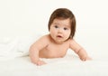 Adorably baby lie on towel in bed, white background. Happy childhood and healthcare concept. Yellow toned