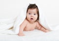 Adorably baby lie on white towel in bed. Happy childhood and healthcare concept