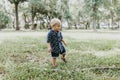 Adorably Happy and Cute Little Caucasian Toddler Baby Boy with Long Blond Hair Laughing, Playing, and Running Outside in Green Nat Royalty Free Stock Photo