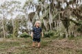 Adorably Happy and Cute Little Caucasian Toddler Baby Boy with Long Blond Hair Laughing, Playing, and Running Outside in Green Nat Royalty Free Stock Photo