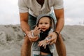 Adorably Perfect Young Father and Baby Toddler Son Family Having Fun Time at the Sandy Beach During Sunset Outside By the Ocean Wa Royalty Free Stock Photo