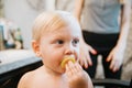 Adorably Precious Cute Little Blond Toddler Boy Showing Off His New Hair Style after Getting His First Hair Cut and Eating Candy Royalty Free Stock Photo