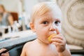 Adorably Precious Cute Little Blond Toddler Boy Showing Off His New Hair Style after Getting His First Hair Cut and Eating Candy Royalty Free Stock Photo