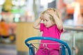 Adorble baby sit on shopping cart in mall Royalty Free Stock Photo