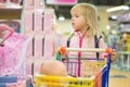 Adorble girl with small shopping cart in kids mall